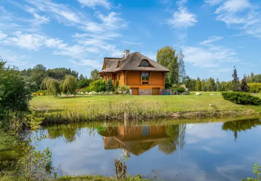 Rezydencja nad Wkrą z drewnianym domem, ogrodem i widokiem na spokojną linię brzegową