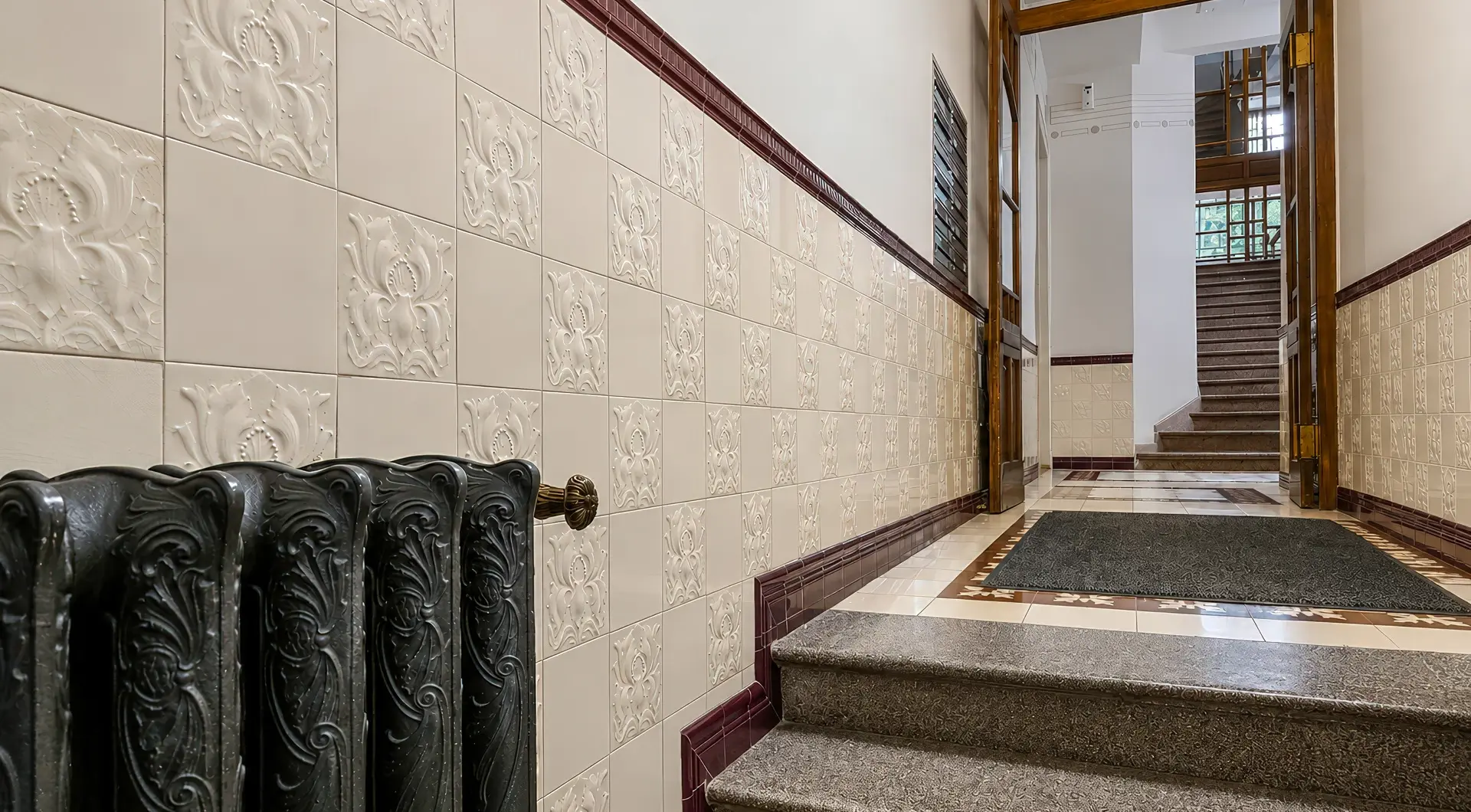 Apartament w zabytkowej kamienicy z elegancką klatką schodową, ozdobnymi płytkami ceramicznymi i historycznymi detalami