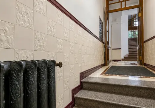 Apartament w zabytkowej kamienicy z elegancką klatką schodową, ozdobnymi płytkami ceramicznymi i historycznymi detalami