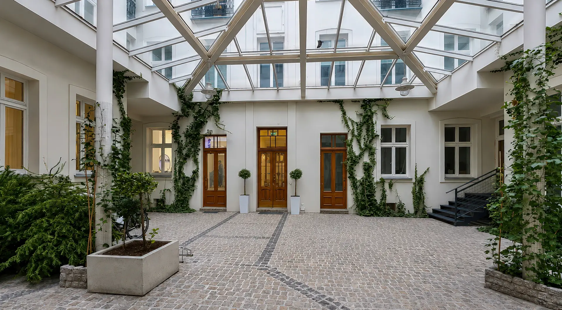 Apartament w zabytkowej kamienicy z przeszklonym dziedzińcem, zielenią i historyczną architekturą w centrum miasta
