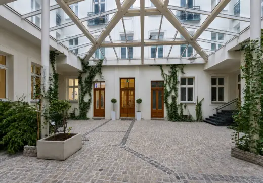 Apartament w zabytkowej kamienicy z przeszklonym dziedzińcem, zielenią i historyczną architekturą w centrum miasta