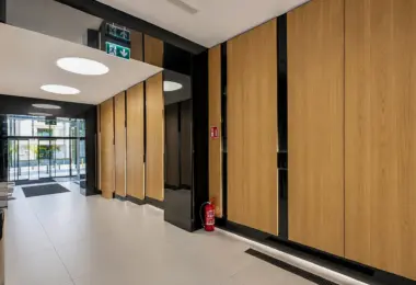 Biuro Krucza wynajem, elegancki korytarz z drewnianymi panelami i wejściem do centrum biurowego