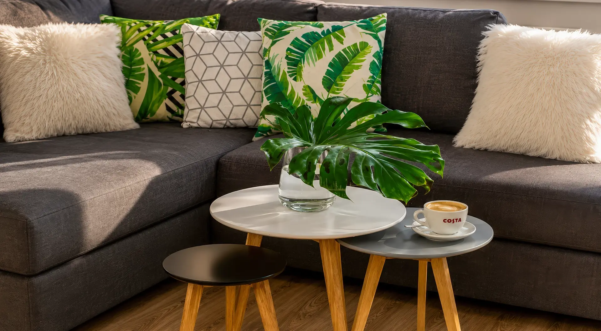 Apartament Warszawa Śródmieście z przytulnym salonem, narożną sofą, designerskimi stolikami kawowymi i nowoczesnymi dodatkami.