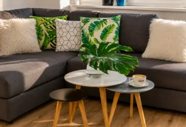 Apartament Warszawa Śródmieście z przytulnym salonem, narożną sofą, designerskimi stolikami kawowymi i nowoczesnymi dodatkami.