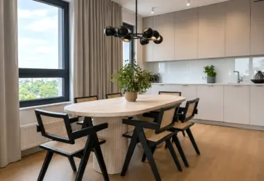 Nowy apartament w Warszawie z elegancką jadalnią, owalnym stołem, designerskimi krzesłami i nowoczesną zabudową kuchenną