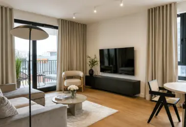 Nowy apartament w Warszawie z przestronnym salonem, dużymi przeszkleniami, telewizorem oraz wyjściem na balkon