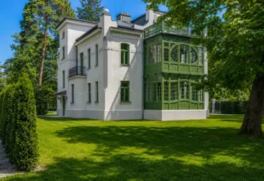 Willa Konstancin Strefa A – boczna elewacja historycznej rezydencji z zieloną oranżerią, balkonem i ogrodem