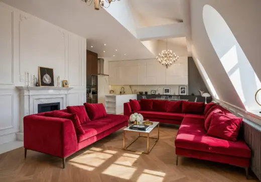 Apartament Kraków Stare Miasto z eleganckim salonem, czerwonymi sofami, kominkiem i jasną kuchnią w tle