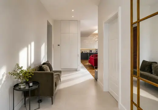Luksusowy apartament w Krakowie – jasny elegancki hol z sofą, dużym lustrem i widokiem na część dzienną
