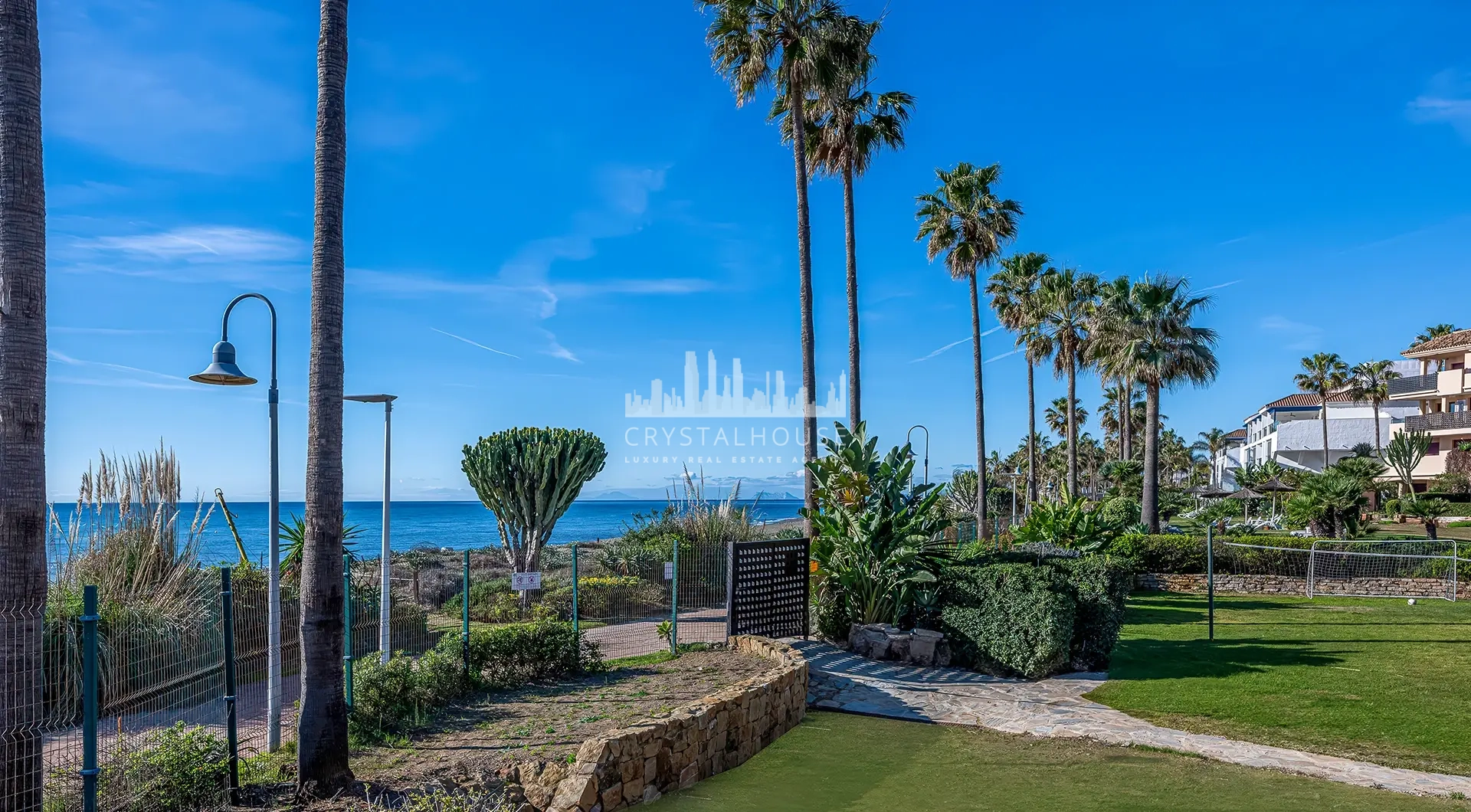 Luxury beachfront apartment in Estepona beachfront gardens with palm trees and coastal view