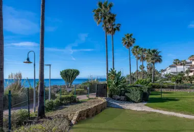 Luxury beachfront apartment in Estepona beachfront gardens with palm trees and coastal view
