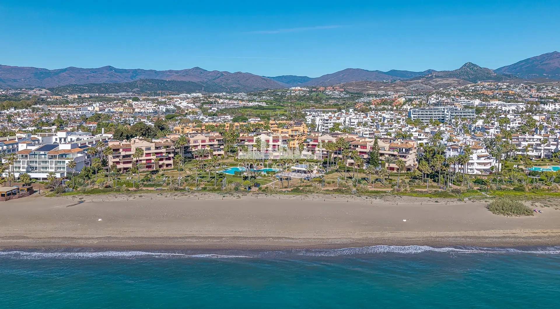Luxury beachfront apartment in Estepona coastal residential complex with pool and mountain views