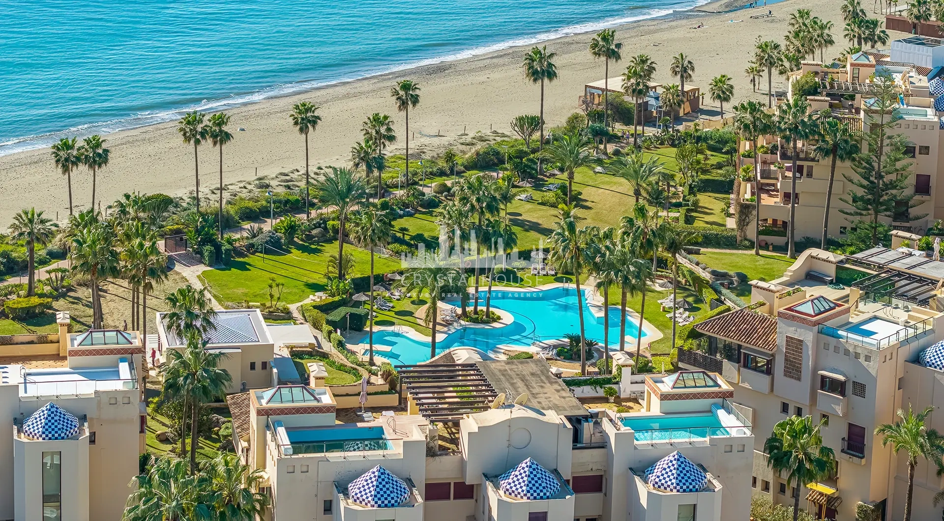 Luxury beachfront apartment in Estepona seaside complex with tropical gardens and swimming pool