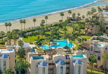 Luxury beachfront apartment in Estepona seaside complex with tropical gardens and swimming pool