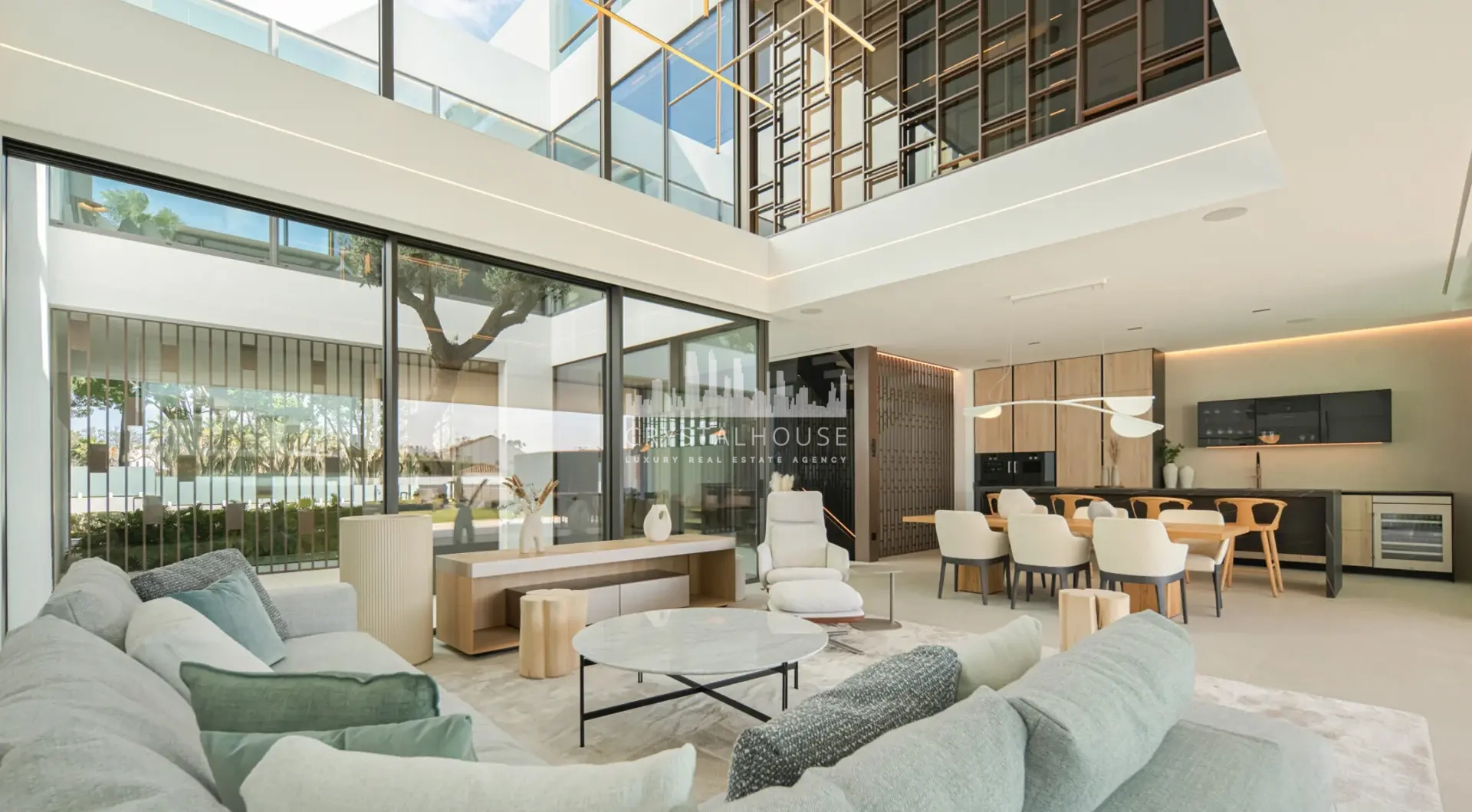 Luxury villa Marbella Golden Mile open plan living and dining area with double height ceiling and glass walls
