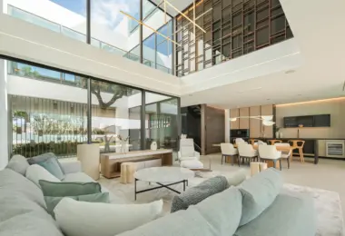 Luxury villa Marbella Golden Mile open plan living and dining area with double height ceiling and glass walls