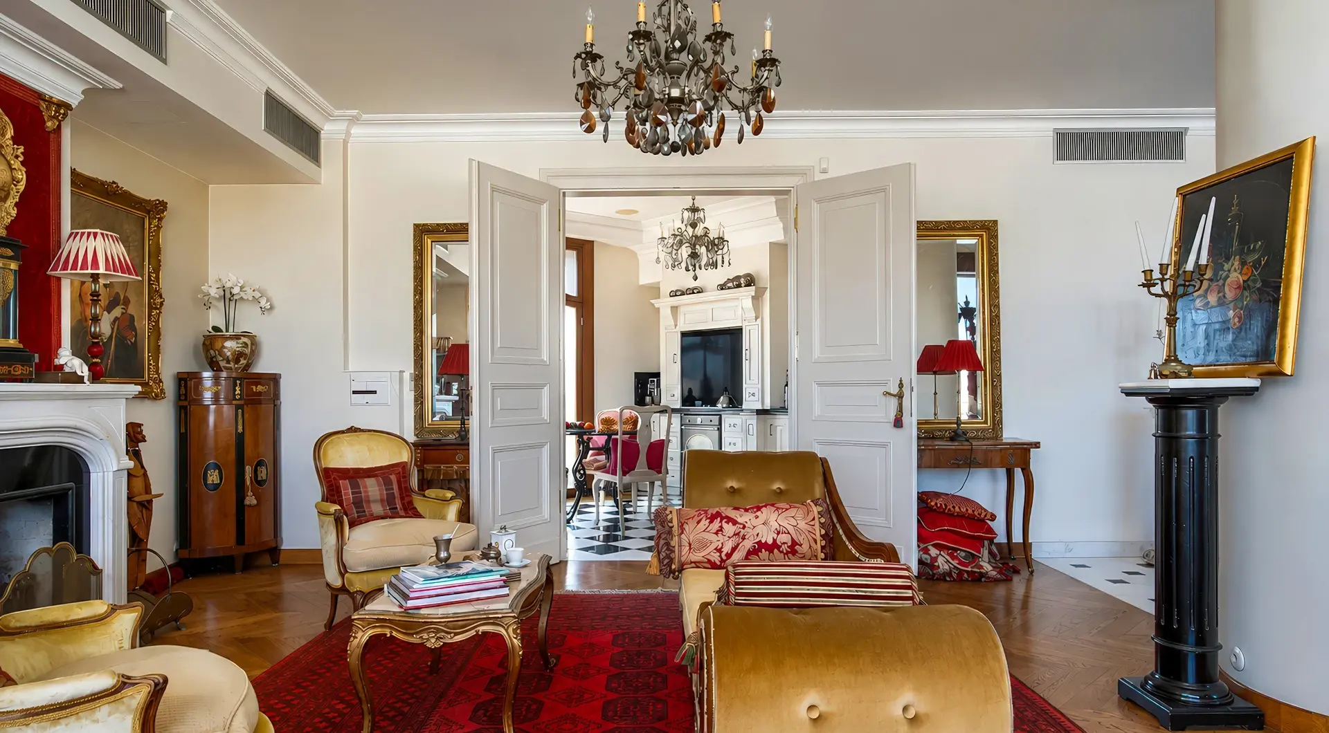Penthouse Rezydencja Opera Warszawa – elegancki salon z kominkiem, klasycznymi meblami i przejściem do kuchni