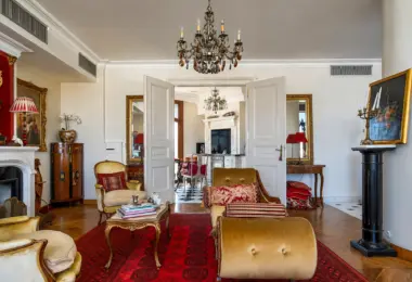 Penthouse Rezydencja Opera Warszawa – elegancki salon z kominkiem, klasycznymi meblami i przejściem do kuchni