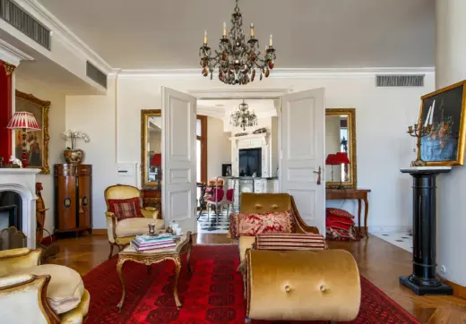 Penthouse Rezydencja Opera Warszawa – elegancki salon z kominkiem, klasycznymi meblami i przejściem do kuchni