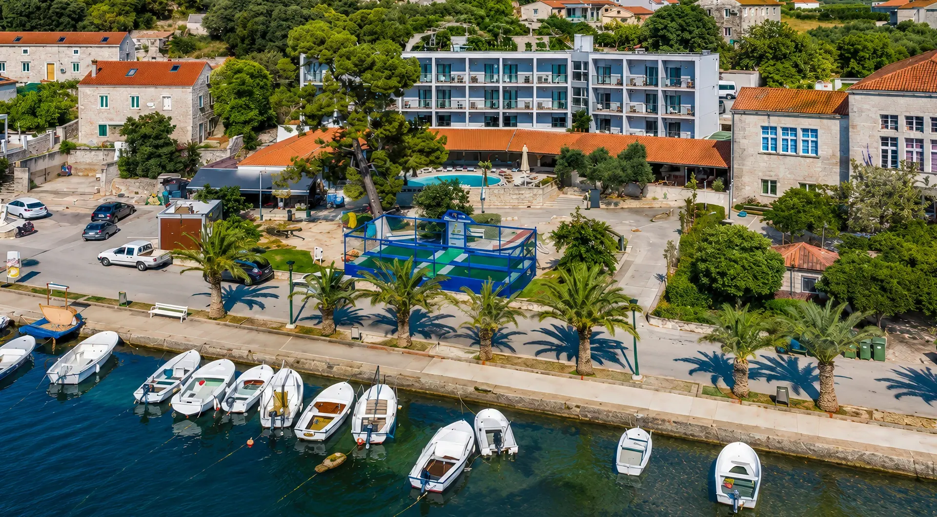 Inwestycje w Chorwacji – kompleks hotelowy nad morzem na wyspie Korčula z widokiem na marinę, palmy i zabudowę śródziemnomorską