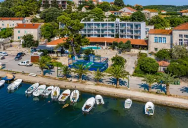 Inwestycje w Chorwacji – kompleks hotelowy nad morzem na wyspie Korčula z widokiem na marinę, palmy i zabudowę śródziemnomorską