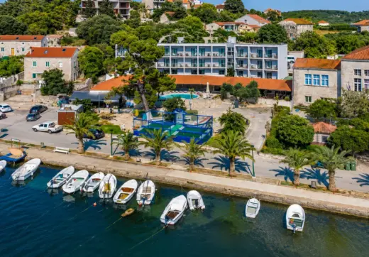 Inwestycje w Chorwacji – kompleks hotelowy nad morzem na wyspie Korčula z widokiem na marinę, palmy i zabudowę śródziemnomorską