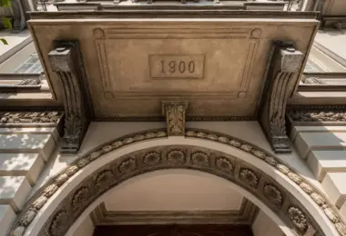 Penthouse w kamienicy Warszawa Śródmieście w zabytkowej kamienicy z dekoracyjną fasadą i datą 1900 nad wejściem