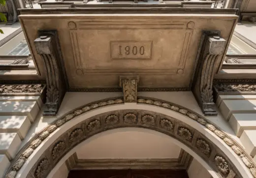 Penthouse w kamienicy Warszawa Śródmieście w zabytkowej kamienicy z dekoracyjną fasadą i datą 1900 nad wejściem