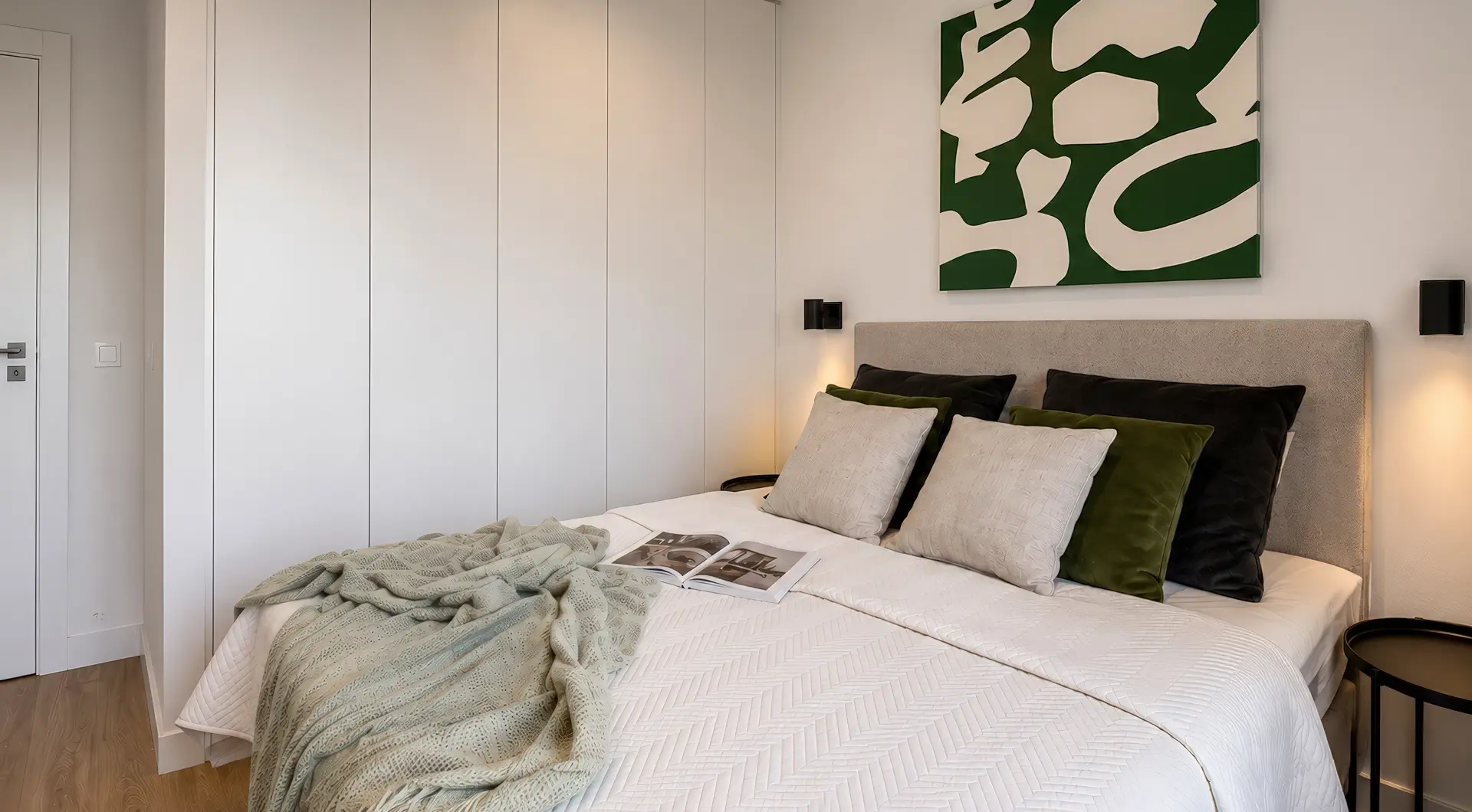 Apartament Holm Skanska – elegancka sypialnia z dużym łóżkiem, pojemną szafą w zabudowie oraz designerskimi dodatkami w nowoczesnym stylu.