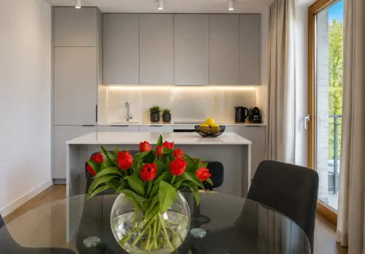 Apartament Warszawa Mokotów z elegancką kuchnią, wyspą kuchenną, częścią jadalnianą oraz nowoczesną zabudową na wymiar