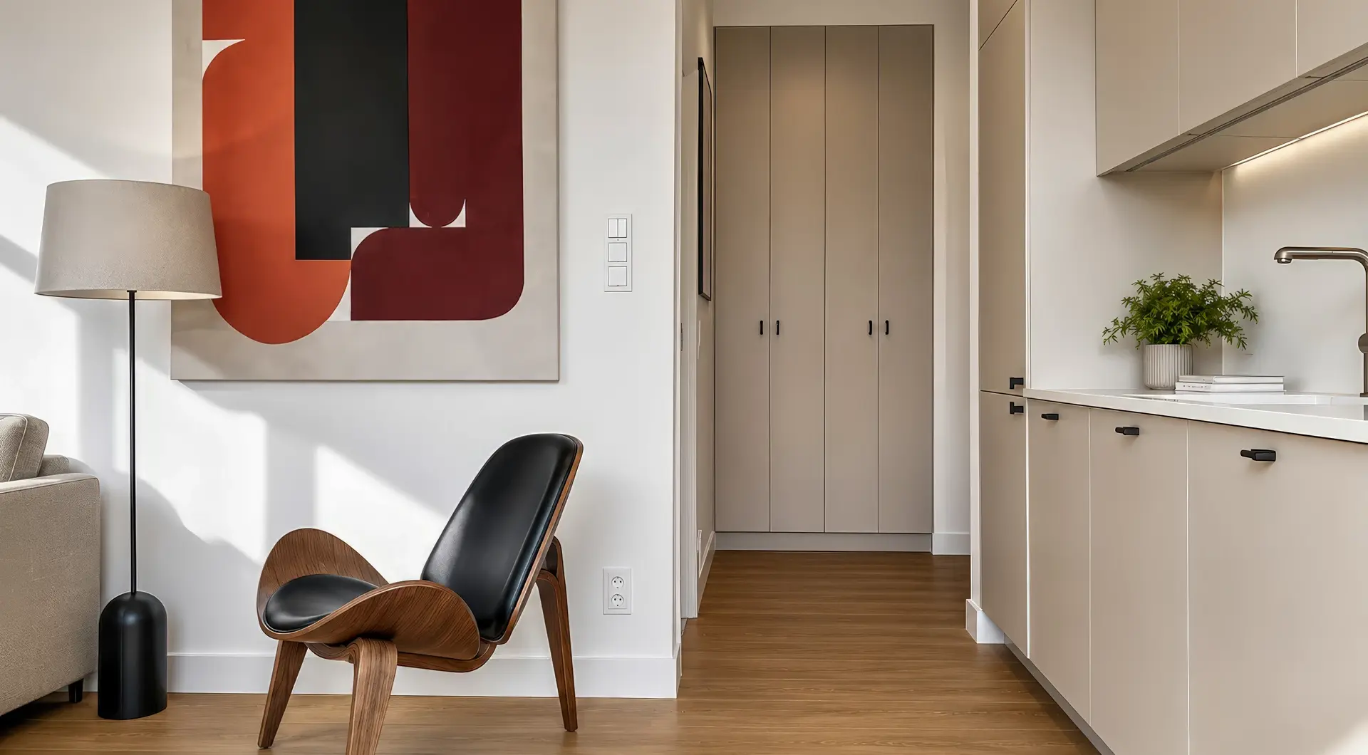Apartament Warszawa Śródmieście z designerskim fotelem, nowoczesną kuchnią w zabudowie oraz eleganckimi dodatkami w minimalistycznym stylu.