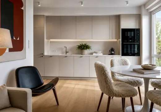 Apartament Warszawa Śródmieście z nowoczesną kuchnią w zabudowie, designerską jadalnią i dużymi oknami zapewniającymi naturalne światło.