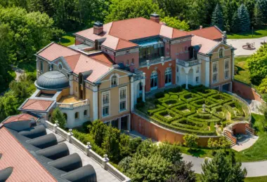 Luksusowa rezydencja pod Warszawą z ogrodem francuskim, pałacową architekturą, tarasami, czerwonym dachem i widokiem z lotu ptaka