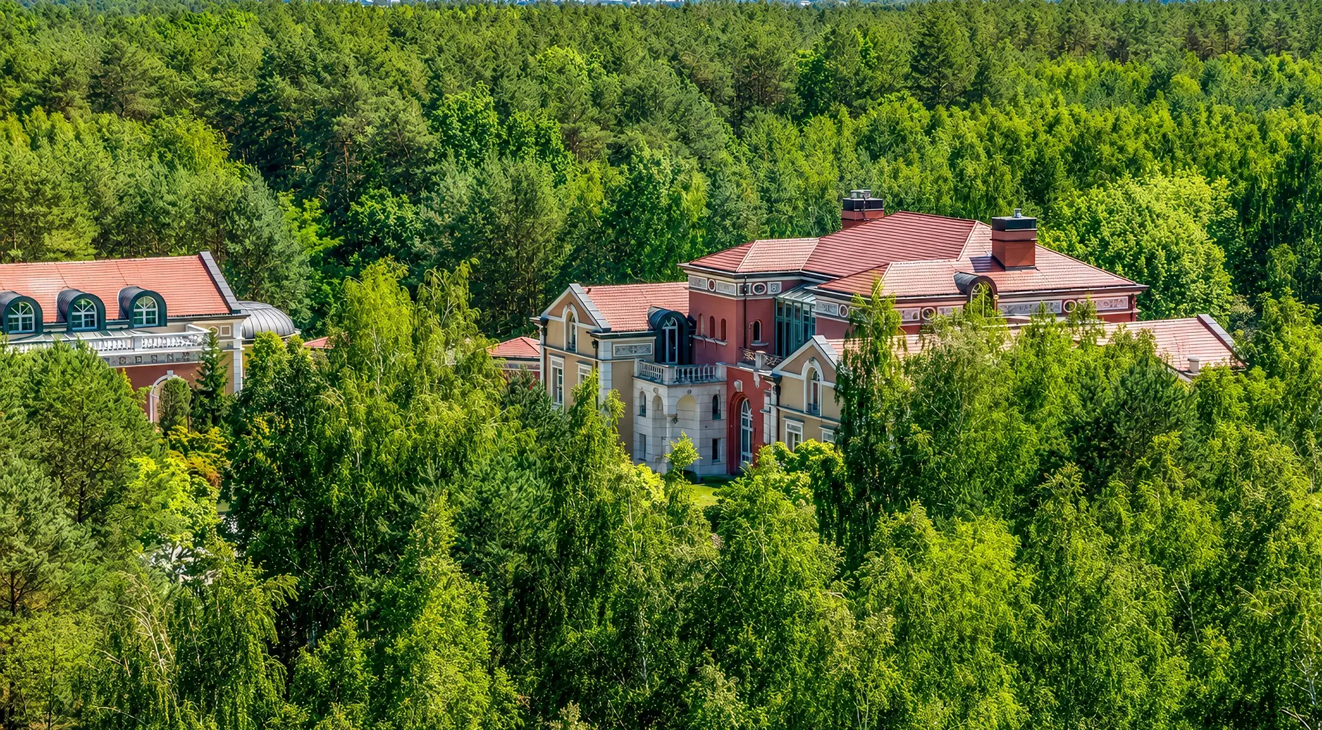 Luksusowa rezydencja pod Warszawą otoczona rozległym lasem, z pałacową architekturą, czerwonym dachem i wyjątkową prywatnością wśród zieleni