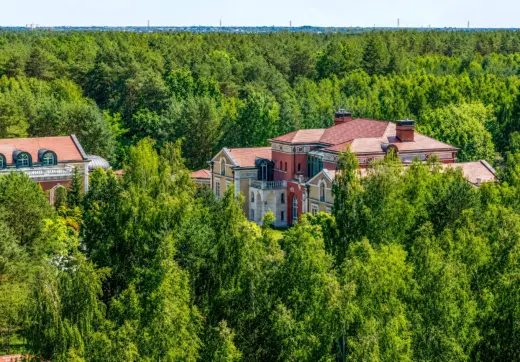 Luksusowa rezydencja pod Warszawą otoczona rozległym lasem, z pałacową architekturą, czerwonym dachem i wyjątkową prywatnością wśród zieleni