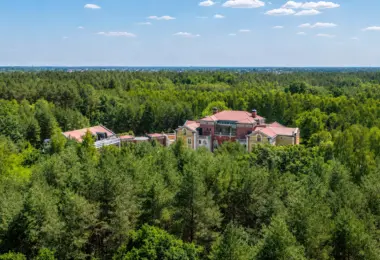 Luksusowa rezydencja pod Warszawą położona pośród rozległych lasów, z pałacową architekturą, czerwonym dachem i wyjątkową prywatnością