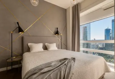 Luksusowy apartament Złota 44 z elegancką sypialnią, designerską ścianą za łóżkiem i widokiem na wieżowce Warszawy
