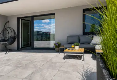 Apartament na wynajem Mokotów – przestronny taras z sofą, fotelem wiszącym i zielenią
