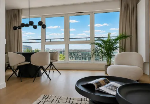 Apartament na wynajem Mokotów – jasny salon z jadalnią, dużymi oknami i widokiem na miasto